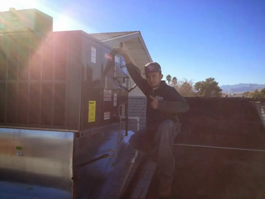 HVAC technician performing Heat Pump Repair on a rooftop unit in New London
